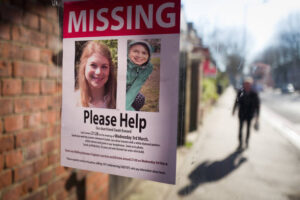 A missing child poster with a neighborhood in the background.